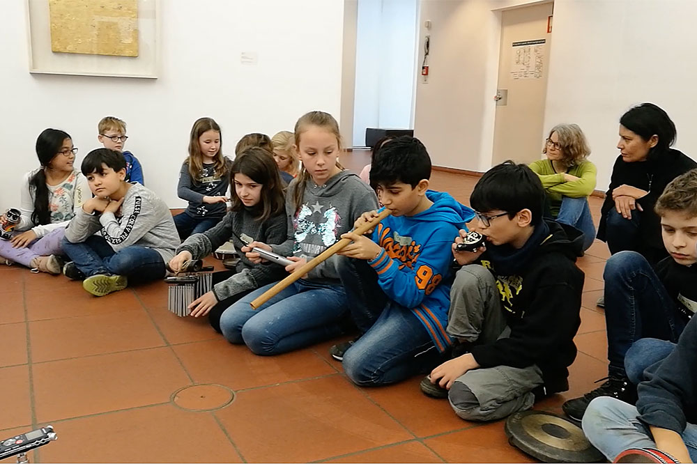 Eine Gruppe Grundschulkinder zu Beginn eines Klangmalerei-Workshops im Dewey Lab des Museum Ludwig